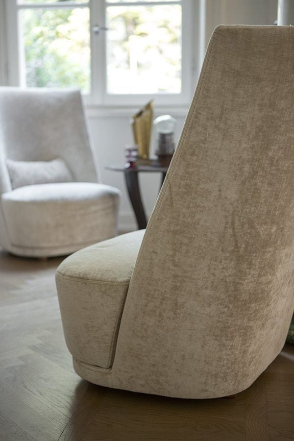 This armchair's towering backrest envelops you in comfort and its sumptuous fabric upholstery invites you to sit back, relax