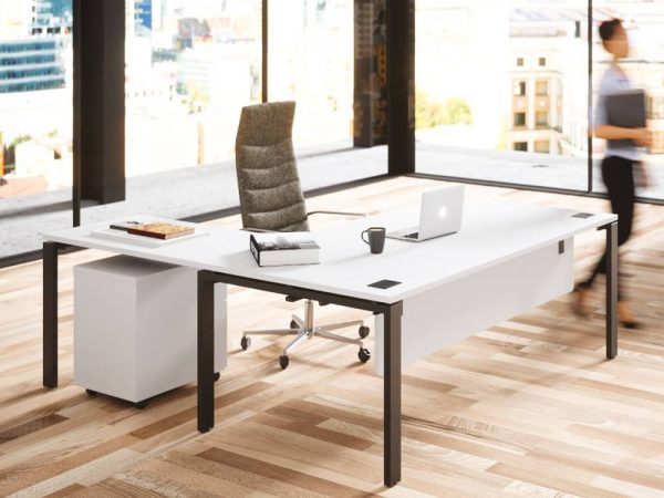 A collaborative office desk with multiple workstations, facilitating teamwork and communication for managers.